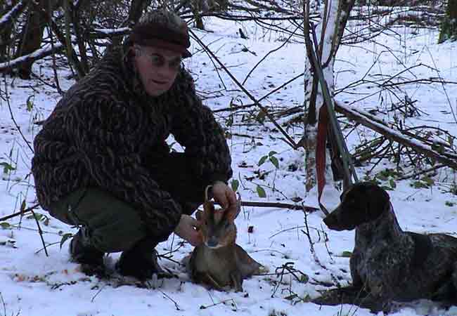 Man and hunting dog in snow with Muntjac cull